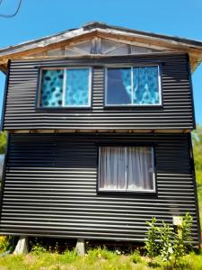 a house with two windows on the side of it at Cabañas atardeceres. in Valdivia