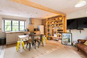 cocina y comedor con mesa y sillas en ‘The Little House on The Priory’ with Hot Tub, en Abergavenny