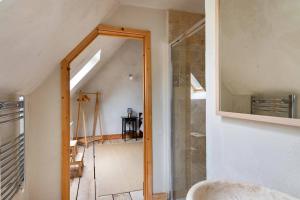 a bathroom with a mirror and a hallway at ‘The Little House on The Priory’ with Hot Tub in Abergavenny