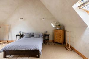 a bedroom with a bed and a dresser in a attic at ‘The Little House on The Priory’ with Hot Tub in Abergavenny