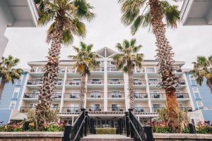 a hotel with palm trees in front of it at Wild Dunes Resort - Sweetgrass Inn and Boardwalk Inn in Isle of Palms