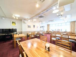 an empty classroom with tables and a piano at Okasan Hotel - Vacation STAY 45146v in Ogaki