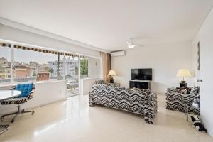 a living room with a table and chairs and a television at Piso con 2 habitaciones, 2 terrazas y piscina in Torremolinos
