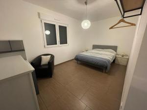 1 dormitorio pequeño con 1 cama y 1 silla en L'Orée des Champs, en Lérouville