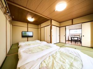 a bedroom with two beds and a tv in it at Okasan Hotel - Vacation STAY 66120v in Ogaki