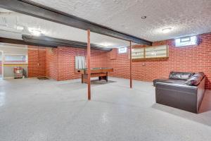 a room with a ping pong table in a brick wall at Elegant Pataskala Home with Hot Tub and Fire Pit! in Pataskala