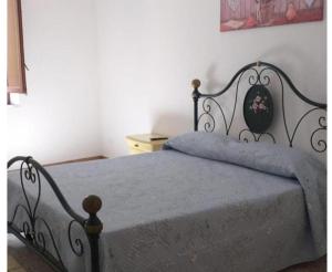 sypialnia z czarnym łóżkiem i niebieskim kocem w obiekcie ELICO A Sicily w mieście Sambuca di Sicilia