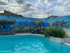 CONFORT HOTEL ARAPIRACA في أرابيراكا: مسبح أمام جدار فيه لوحة جدارية
