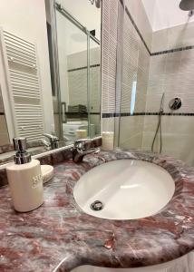 W łazience znajduje się umywalka z marmurowym blatem. w obiekcie Baia Lunare w mieście Vado Ligure
