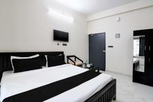a bedroom with a large bed and a tv on the wall at OYO Flagship SS INN Hotels & Homes in Khandagiri
