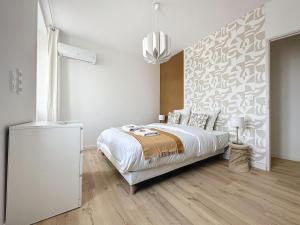 ein weißes Schlafzimmer mit einem Bett und einer Wand in der Unterkunft [PARENTHESE] Le ChiFouMi - 6pers in Saint-Jory