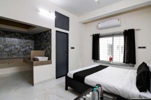 a bedroom with a bed and a window and a sink at OYO Flagship SS INN Hotels & Homes in Khandagiri