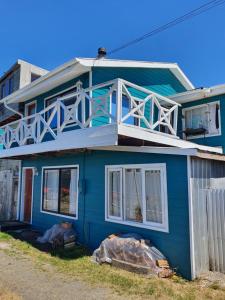 a blue house with a balcony on top of it at Hostal Isla Mágica in Castro