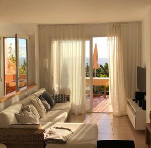 a living room with a white couch and a balcony at Vivienda Atlantico in Tazacorte