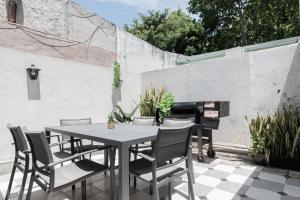 un patio con mesa, sillas y chimenea en Fliphaus Salvador 6000 - 2 Bd Duplex Palermo en Buenos Aires