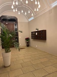 バーリにあるB & B Giuseppe & Gretaの鉢植えの植物とシャンデリアが備わる広い客室です。