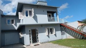 a blue and white house with a balcony at Sobrado Completo Belíssima in Pelotas