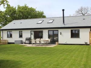 a white house with a lawn in front of it at 4 Bed in High Bickington 86720 in High Bickington