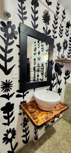 baño con lavabo y espejo en la pared en MESON AMELIA en San Miguel de Allende