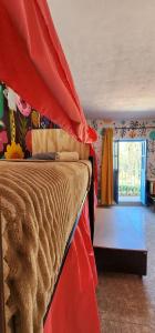 1 dormitorio con 1 cama con dosel rojo en MESON AMELIA en San Miguel de Allende