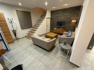 a living room with a couch and a staircase at Maison 3 chambres proximité aéroport et grand axes in Charleroi
