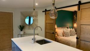 een keuken met een wastafel en een slaapkamer met een bed bij Parkside Lodge - Luxury Coastal Hideaway for Two in Brixham