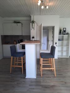 eine Küche mit zwei Hockern und einer Theke in einem Zimmer in der Unterkunft Ferienwohnung K1 in Hambühren