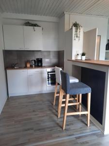 a kitchen with a counter and a chair and a table at Ferienwohnung K1 in Hambühren