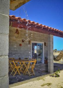 eine Terrasse mit einem Holztisch und ein Gebäude in der Unterkunft Alto das Carnaúbas Chalé in Luis Correia