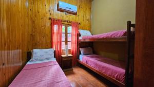 1 dormitorio con 2 literas y ventana en Cabañas Rincon Santa Maria en Puerto Iguazú