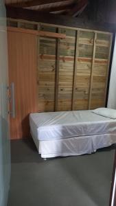 a bedroom with a bed with wooden cabinets at Caiowa Floripa guesthouse in Florianópolis