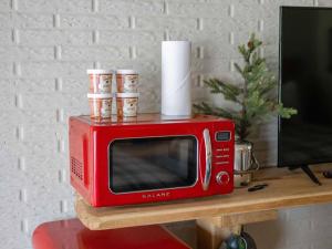 a red microwave sitting on top of a table at Stonegate Lodge 2 Queen Beds Fast WiFi 50in TV Salt Water Pool Room # 305 in Eureka Springs