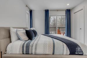 1 dormitorio con 1 cama con cortinas azules y ventana en Chalet Bellevue Luxe avec Spa et local à velo, en Pont-Rouge