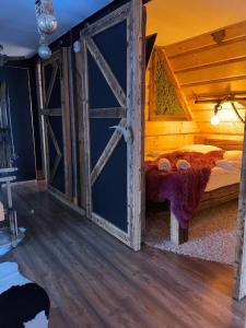 1 dormitorio con cama de madera y puerta abierta en Viking Shelter Apartament, en Zakopane