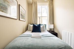 a bedroom with a large bed with blue pillows at Marylebone Luxury 2 Bed Appartment in London