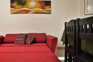 un sofá rojo en una sala de estar con una pintura en la pared en Depto con hermosa vista al lago y cerros cerca de todo en San Carlos de Bariloche