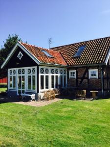 une maison avec un toit rouge et une cour dans l'établissement Hönshuset Kullabygden, à Höganäs