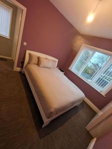 a bed in a room with a window at 3 bed home, pool-hot tub & ev charger in Darlington