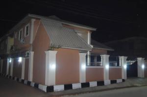 une maison avec des lumières sur son côté la nuit dans l'établissement Asoro Apartments, à Benin City