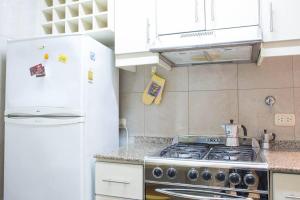 a kitchen with a stove and a white refrigerator at 2 amb. frente al Bótanico Rep Arabe Siria y Santa Fe in Buenos Aires