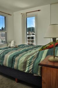 1 dormitorio con 1 cama y 1 lámpara en una mesa en Depto con hermosa vista al lago y cerros cerca de todo en San Carlos de Bariloche