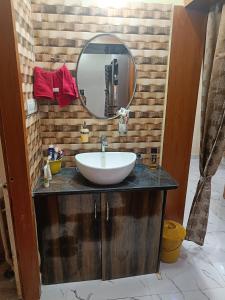 a bathroom with a sink and a mirror at Adbhut Nivas (Home Stay) in Bhopal
