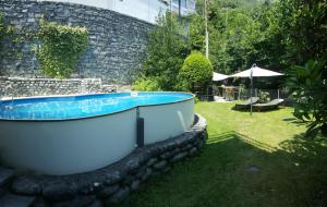 eine Badewanne in einem Hof neben einer Steinmauer in der Unterkunft Sonnenschein in Brione sopra Minusio