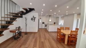 cocina y sala de estar con mesa y escalera en Casa Lorea, en Barruelo de Santullán