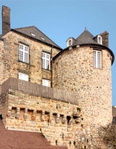 um grande edifício de tijolos com janelas em cima em La maison sur les remparts em Domfront