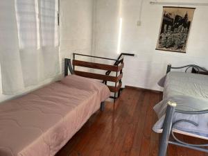 um quarto com duas camas e uma cadeira. em María Chusena alojamiento 2 em Fray Bentos