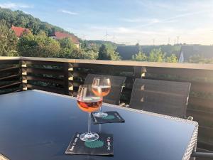 a glass of wine sitting on a table on a balcony at Das Tor zur Rhön 