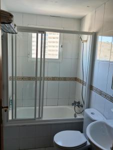 łazienka z wanną, toaletą i umywalką w obiekcie Torres Montecarlo Apartmento con vistas al mar w mieście Benidorm