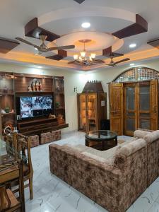 a living room with a large couch and a flat screen tv at Adbhut Nivas (Home Stay) in Bhopal