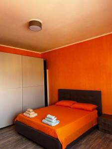 a bedroom with a bed with orange walls at Kennedy Apartment in Quattromiglia